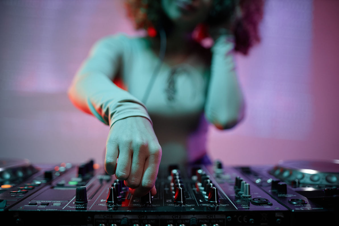 Close up of a DJ's hand as she uses a knob on the DJ mix deck.