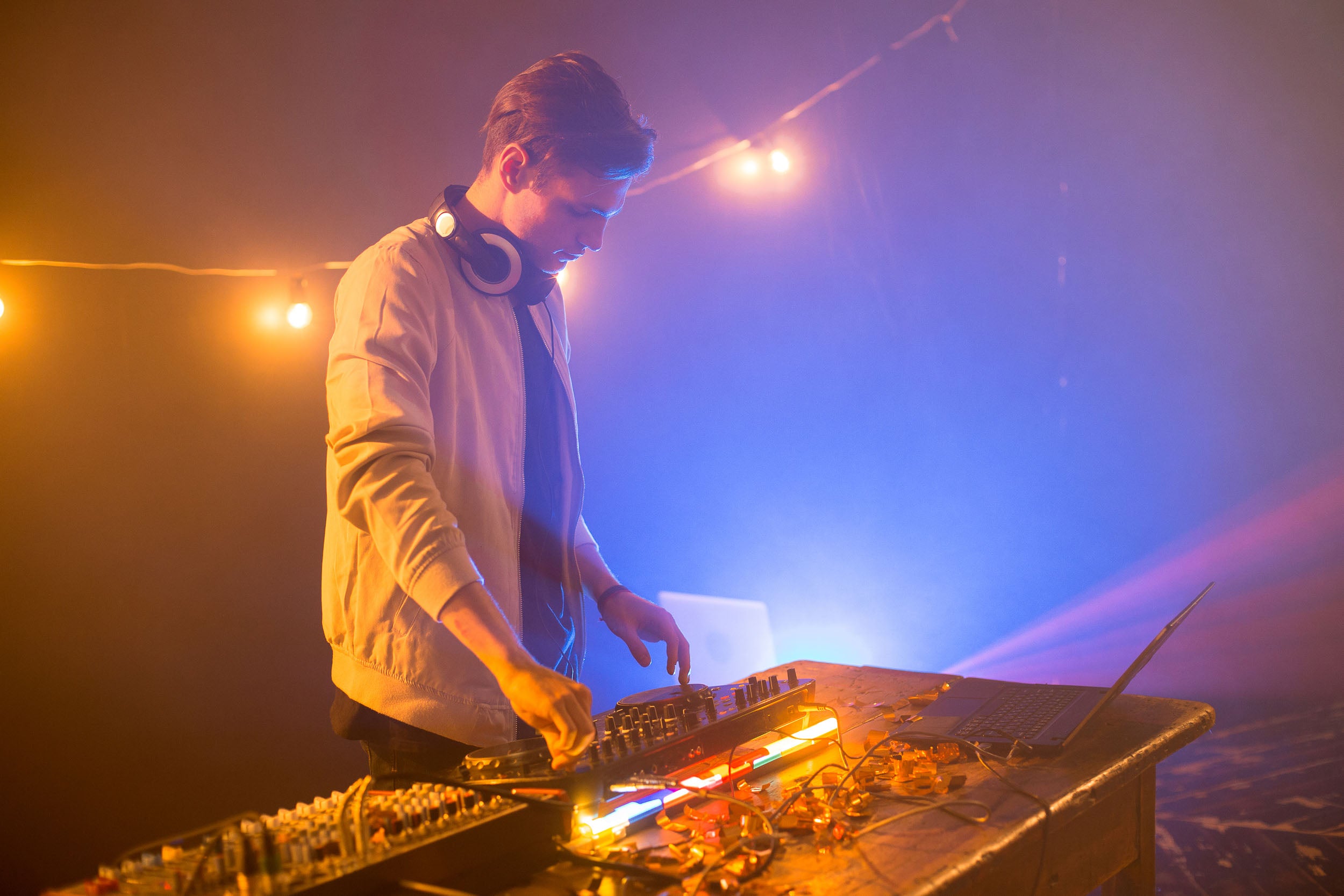 Man on stage using DJ deck. 